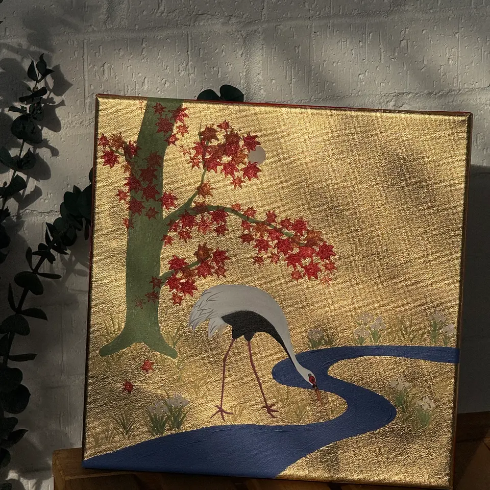 A white crane by a blue stream beneath a red maple tree on a gold ground.