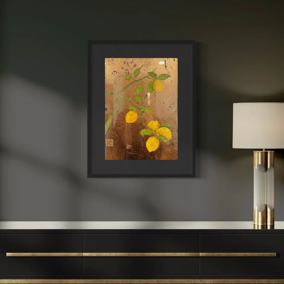 A framed botanical painting of yellow lemons, green leaves, and warm orange tones.