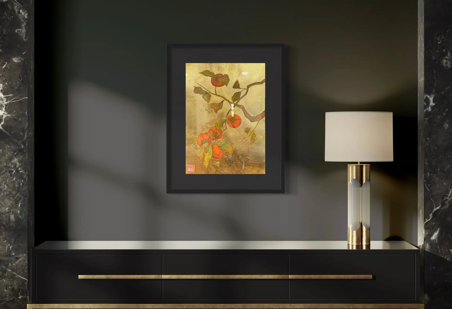 A framed painting of orange persimmons and green leaves with gold accents.